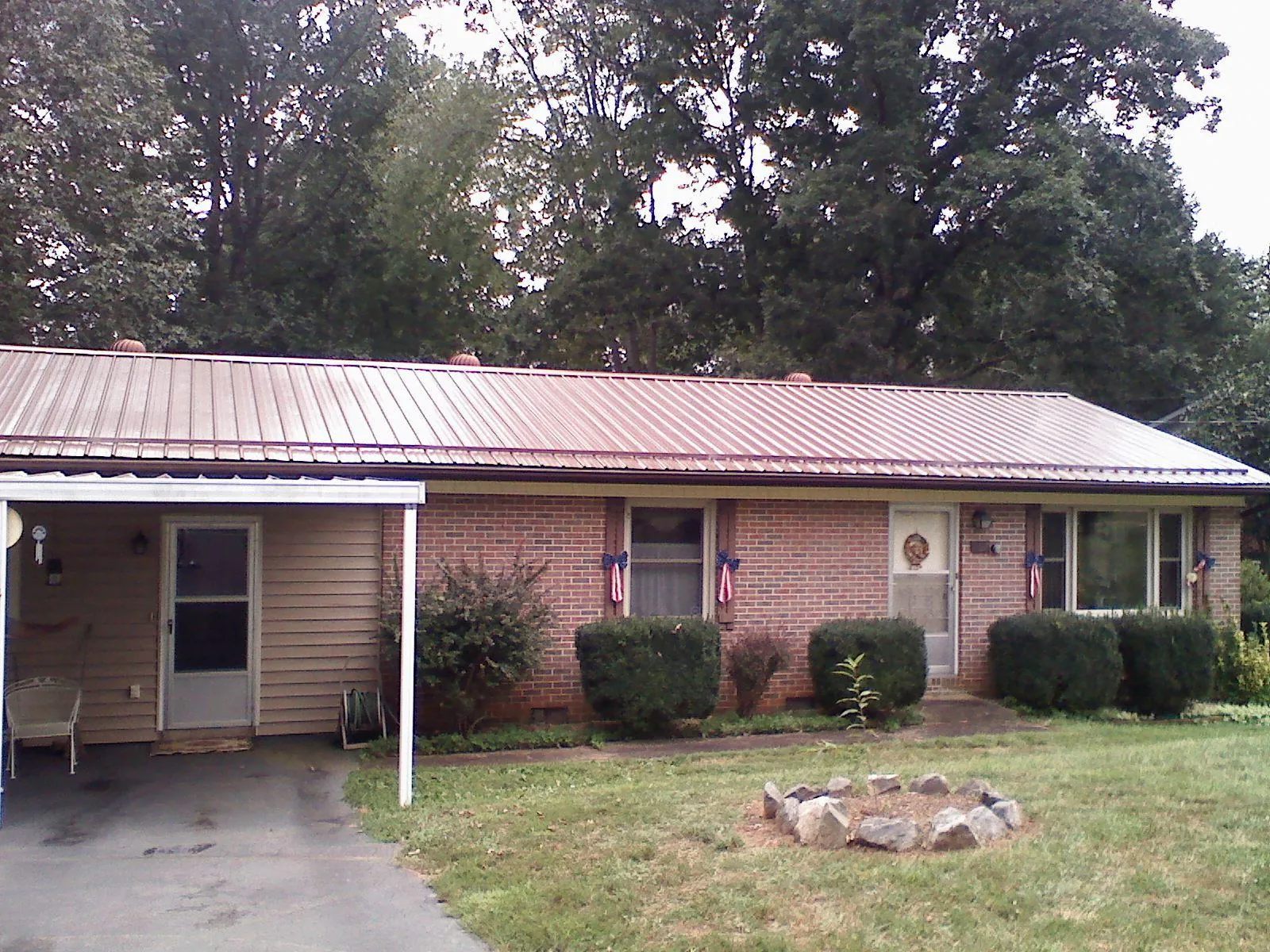 Bronze metal roof and carport on a brick ranch home — Roof Repair work by our crew in Merrill